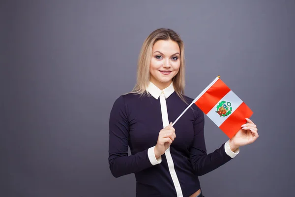 Inmigración y el estudio de lenguas extranjeras, concepto. Una joven sonriente con una bandera de Perú en la mano — Foto de Stock