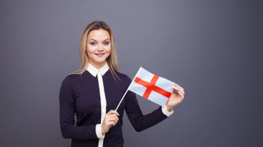 Göçmenlik ve yabancı dil eğitimi, konsept. Elinde İngiltere bayrağı olan gülümseyen genç bir kadın..