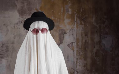 Mutlu Cadılar Bayramı. Sevimli komik Hayalet, dokulu eski bir duvara karşı, antika çelik.