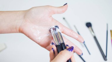 Makyaj fırçalarının temizlenmesi ve bakımı, kadınların elleri kozmetik ürünlerinin fırçasını yıkar.,