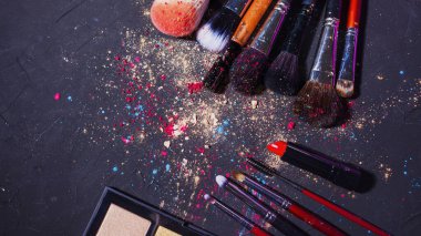 Cosmetics and beauty, still life with a palette of shadows, makeup brushes and a set of lipsticks,
