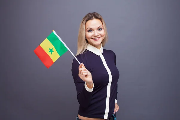 移民与外语学习,概念.一个年轻的微笑的女人手里拿着塞内加尔国旗 — 图库照片