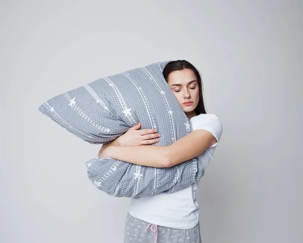 Sleep and drowsiness, a young woman hugs a pillow and sleeps standing up — Stock Photo, Image