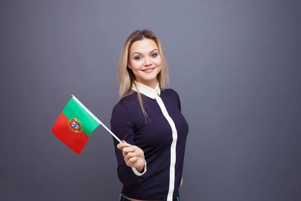 Maahanmuutto ja vieraiden kielten opiskelu, käsite. Nuori hymyilevä nainen Portugalin lippu kädessään. — kuvapankkivalokuva