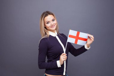 Göçmenlik ve yabancı dil eğitimi, konsept. Elinde İngiltere bayrağı olan gülümseyen genç bir kadın..