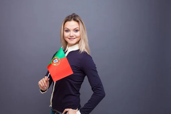 Imigrace a studium cizích jazyků, koncepce. Mladá usměvavá žena s vlajkou Portugalska v ruce. — Stock fotografie