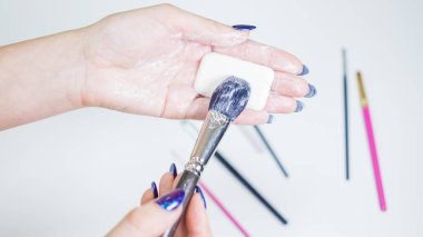 Makyaj fırçalarının temizlenmesi ve bakımı, kadınların elleri kozmetik ürünlerinin fırçasını yıkar.,