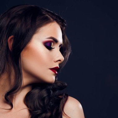 Gorgeous young brunette in a chic evening look. Scarlet lips and eye shadow,