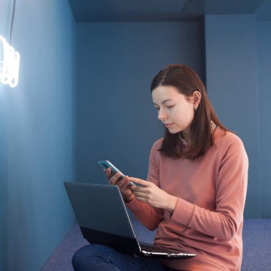 Serbest çalışan biri dizüstü bilgisayarda çalışıyor. Genç ve güzel bir kadın dizüstü bilgisayarını kucağında tutuyor.