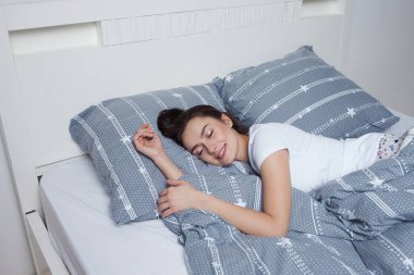 Sağlıklı geceler yatakta uyuyun, güzel esmer kadın uyuyor.