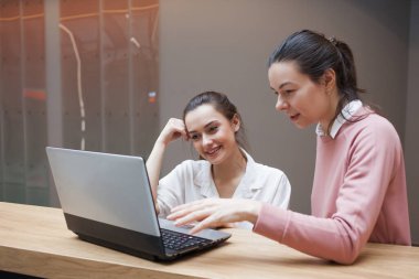 İşteki iki genç kadın bir iş projesini tartışıyorlar..