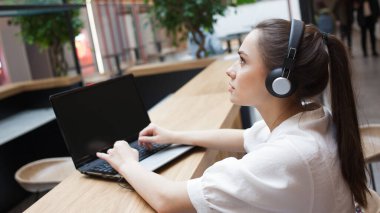 Çevrimiçi görüşme, iş ya da kişisel sohbet, konsept. Kulaklıklı çekici genç bir kadın.