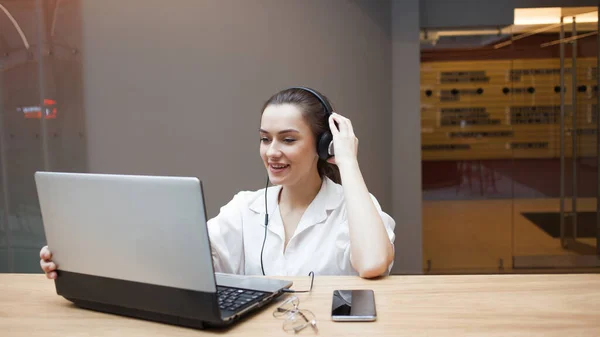 Online interview, business or personal conversation online, concept. Young attractive woman in headphones