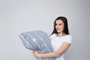 Uyku ve uykusuzluk, genç bir kadın yastığa sarılıyor ve ayakta uyuyor.