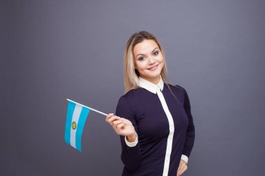 Göçmenlik ve yabancı dil eğitimi, konsept. Elinde Arjantin bayrağı olan gülümseyen genç bir kadın..