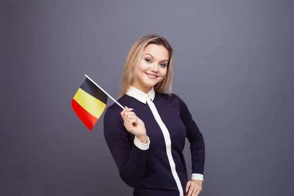 Einwanderung und Fremdsprachenstudium, Konzept. Eine junge lächelnde Frau mit einer belgischen Flagge in der Hand. — Stockfoto