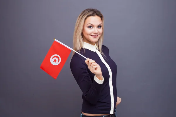 Imigrace a studium cizích jazyků, koncepce. Mladá usměvavá žena s tuniskou vlajkou v ruce. — Stock fotografie