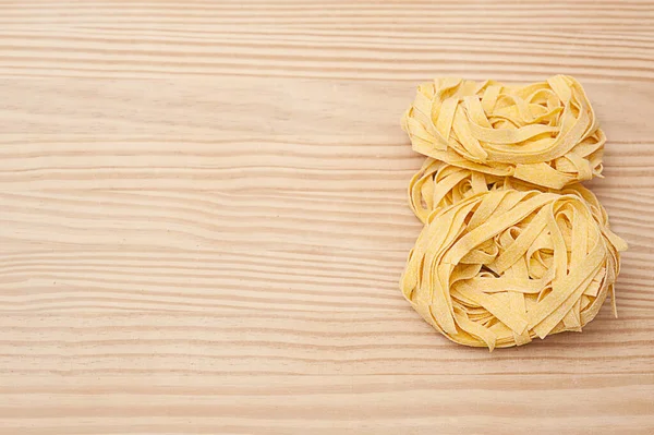 Italian fettuccine on a wooden background. recipe for homemade pasta — Stock Photo, Image