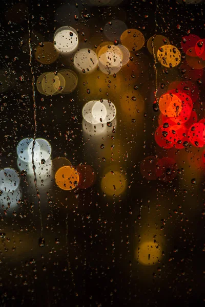 Rain drops on the window with traffic bokeh light — Stock Photo, Image