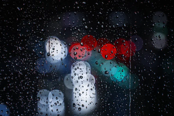 Chuva cai na janela com semáforo bokeh — Fotografia de Stock