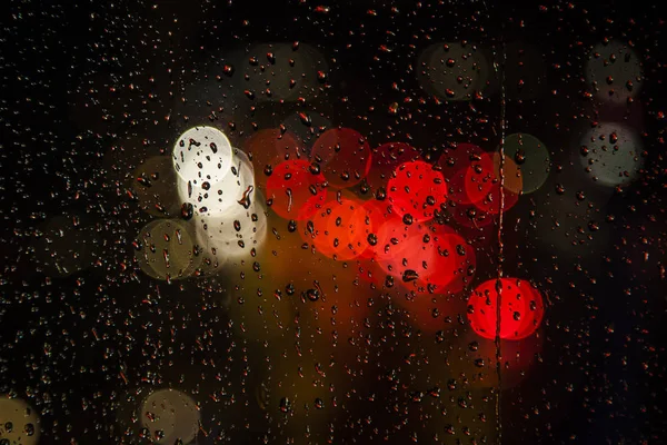 Rain drops on the window with traffic bokeh light — Stock Photo, Image