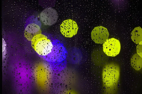 Chuva cai na janela com semáforo bokeh — Fotografia de Stock