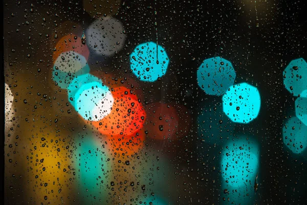 Rain drops on the window with traffic bokeh light — Stock Photo, Image