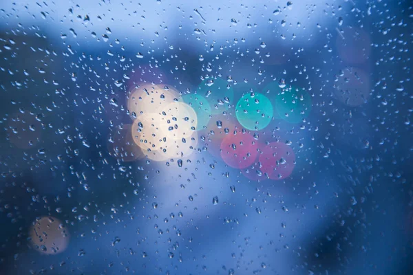 Chuva cai na janela com semáforo bokeh — Fotografia de Stock