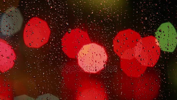 Gouttes de pluie sur la fenêtre avec un feu de circulation coloré — Video