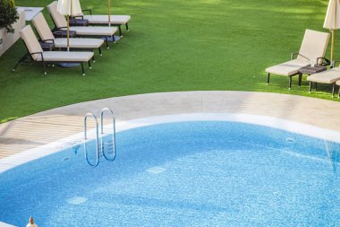 Yeşil çimen ve mavi su arka planlı havuz