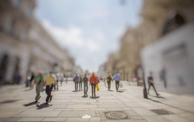 Kalabalık kalabalık şehir caddesinde yürüyor.