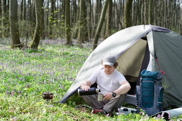 O turista bebe chá em um acampamento de tenda . — Fotografia de Stock