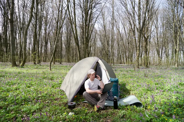 Homem trabalhando ao ar livre em um acampamento de tenda . — Fotografia de Stock