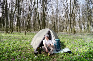 Turistik bir çadır kampında çay içer.