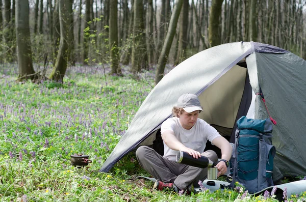Турист пьет чай в палаточном лагере . — стоковое фото