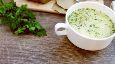 Beyaz bir tabak içinde croutons mantar çorbası üzerinde ahşap bir tablodur. Video Dolly ile çekildi.