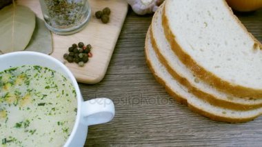 Beyaz bir tabak içinde croutons mantar çorbası üzerinde ahşap bir tablodur. Video Dolly ile çekildi.