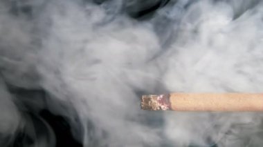 Siyah bir zemin üzerine sigara içiyorum. Arka ışık duman açıkça görülmeye başlıyor.