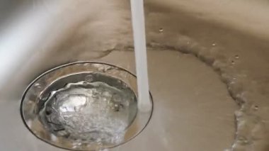 Bir mutfak lavabo musluk suyu doldurur.