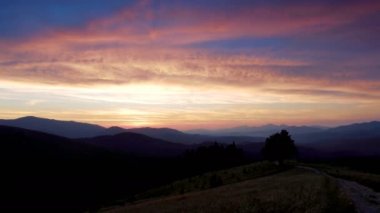 Zaman atlamalı bir günbatımı Karpat Dağları üzerinde.