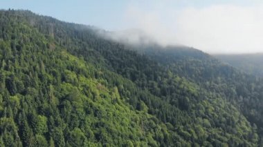 Bulutların arasındaki güzel dağların üzerinde uçan drone.