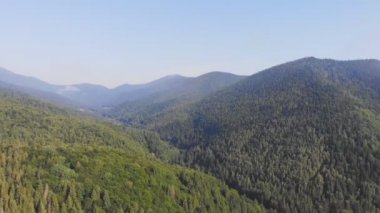 Bulutların arasındaki güzel dağların üzerinde uçan drone.