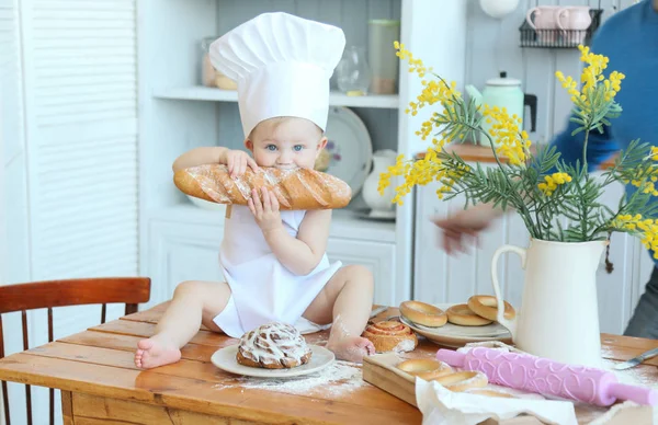 Bebek yemek ev yapımı kekler. Erken ilkbaharda, Paskalya ve küçük bir kız mutfakta Şef'in kılık pişiren ekmek ve bisküvi. Kız un kirlendi. Annemin yardımcı Stok Resim