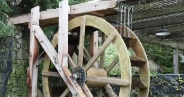 Water wheel of an old-fashioned mill rotating under the pressure of the water stream