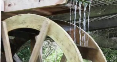 Water wheel of an old-fashioned mill rotating under the pressure of the water stream