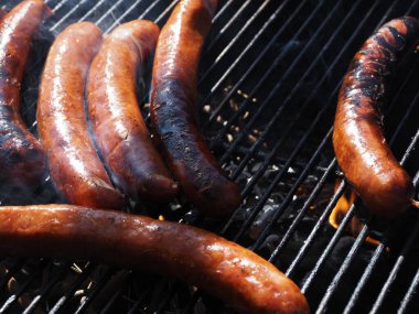 Izgarada ızgara sosis pişiriliyor.