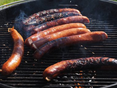 Izgarada ızgara sosis pişiriliyor.