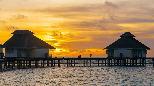 Tropik adada gün batımı, su villaları tatil beldesi