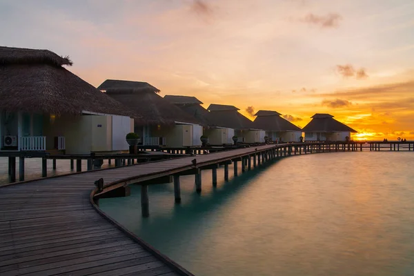 Tropik adada gün batımı, su villaları tatil beldesi