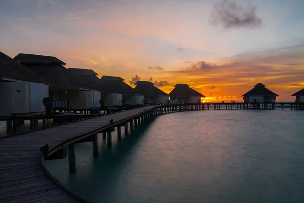 Puesta de sol en isla tropical, complejo de villas acuáticas — Foto de Stock